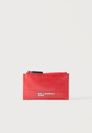 Porte-cartes rouge texturé avec fermeture éclair noire et logo argenté « Karl Lagerfeld Jeans » sur l'avant, sur fond blanc uni.