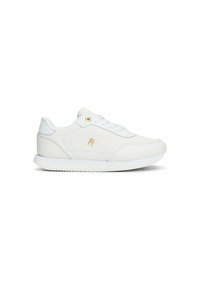 Zapatilla de cuero blanca con textura suave, suela de goma, cierre de cordones y un pequeño logotipo dorado en el lateral.