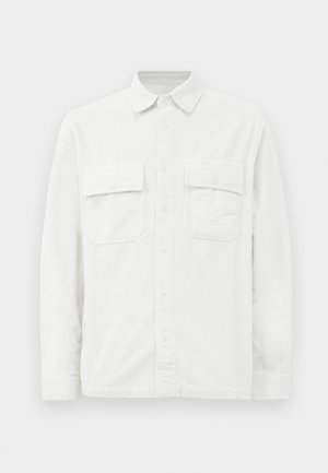 White corduroy shirt with long sleeves, a collar, two chest pockets, and a textured fabric pattern. Button closure down the front.