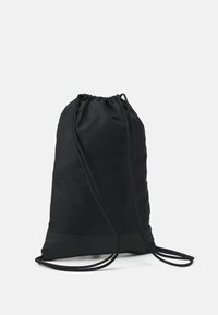 Mochila com cordão preta, feita de um tecido resistente com uma textura suave. Apresenta uma forma arredondada e cordões pretos em contraste.