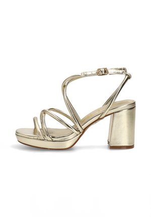 Sandalia dorada con tiras y tacón ancho, hebilla en el tobillo y diseño de punta abierta, con múltiples tiras finas sobre el pie.