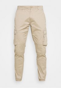 Beige cargobroek van katoen met elastische boorden en zijzakken. Voorzien van een knoopsluiting en een relaxte pasvorm.