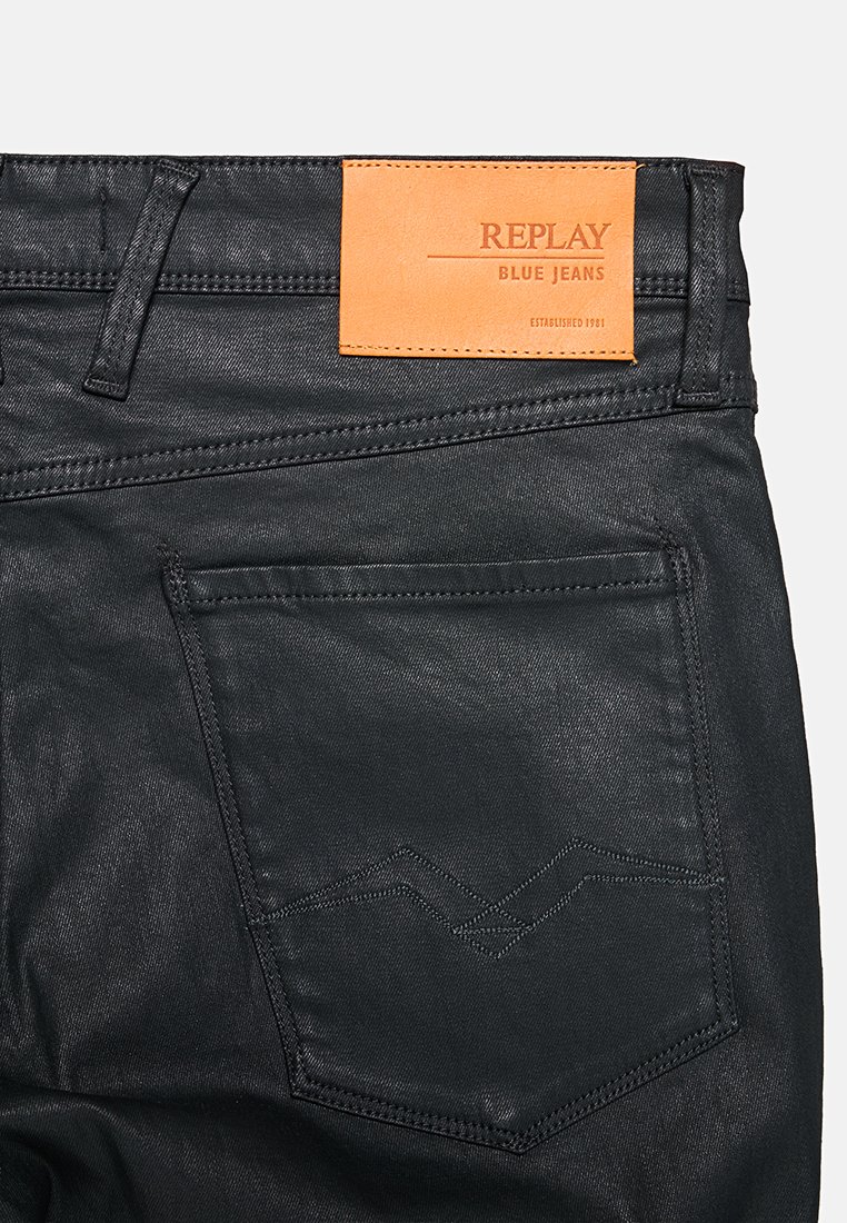 Czarne dżinsy denimowe z tylną kieszenią z zygzakowatym przeszyciem i brązową skórzaną naszywką marki Replay Blue Jeans nad kieszenią.