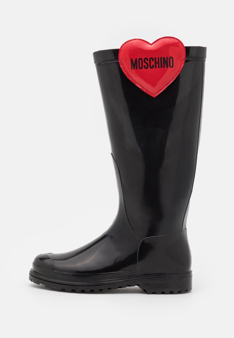 Svart gummistövlar med rund tå, tjock sula och glänsande yta. Utsmyckad med en röd hjärtapplikation märkt "MOSCHINO."