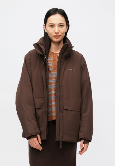 Braune isolierte Jacke mit hohem Kragen, Reißverschluss und großen Vordertaschen. Das Innere zeigt einen gestreiften Pullover in warmen Tönen.