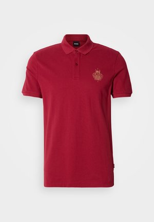 Rød bomulls polo-skjorte med krage, korte ermer og en gullbrodert logo på venstre bryst. Jevn tekstur, klassisk design.