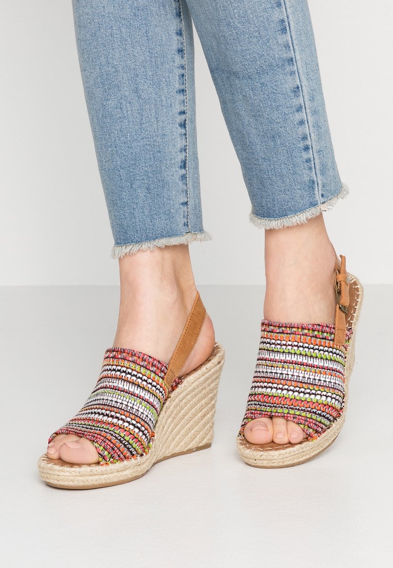 Sandales compensées avec empeigne en tissu multicolore tissé, design à bout ouvert et accents en cuir beige, dotées d'une semelle enveloppée de jute et d'une bride à la cheville.