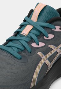 Ciemnoszare buty sportowe z tealowymi sznurówkami i akcentami. Teksturowana cholewka z różowymi detalami i odblaskowym logo po boku.