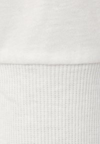 White cotton fabric with a smooth texture, featuring a ribbed cuff at the bottom. The surface is uniform without patterns or additional details.