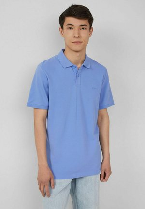 Helles blaues Poloshirt aus Baumwolle, mit klassischem Kragen und einer Zwei-Knopf-Leiste. Kurze Ärmel und minimale Markenkennzeichnung auf der Brust.
