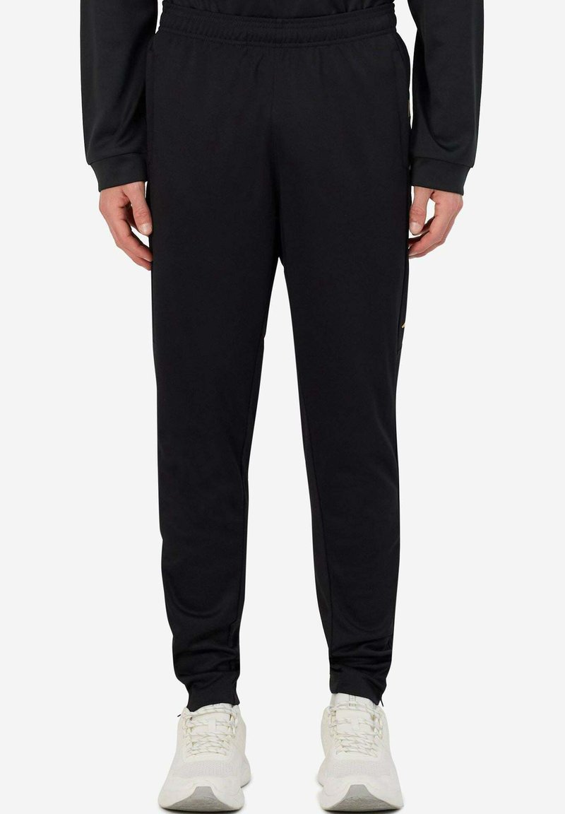 Pantaloni sportivi neri con vita elastica, gamba affusolata e tasche laterali. Realizzati in tessuto morbido e leggero per comfort e libertà di movimento.