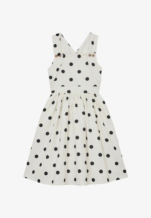 Vestido blanco sin mangas con lunares negros, tirantes con botones y falda fruncida.