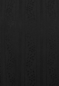 Tissu en dentelle noire présentant des rayures verticales avec des motifs floraux complexes et des détails texturés, offrant une apparence superposée et dimensionnelle.