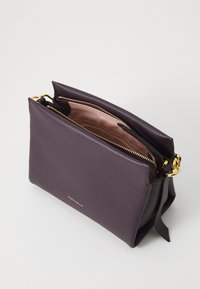 Borsa in pelle viola con due compartimenti con cerniera, dettagli in hardware dorato, esterno testurizzato e fodera interna liscia rosa.