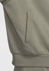 Felpa verde oliva chiaro con tessuto strutturato, polsini a coste e tasca laterale. Design semplice con vestibilità comoda.