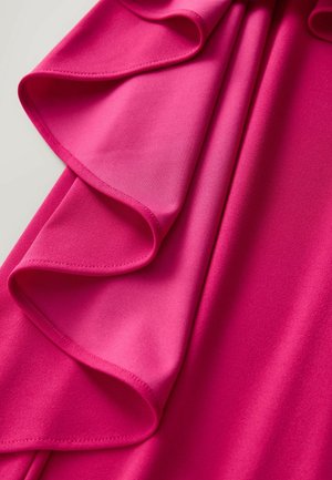 Fuchsia tyg med en slät textur och volangkant, draperad på ett elegant sätt. Färgen är livlig och jämn genom hela tyget.