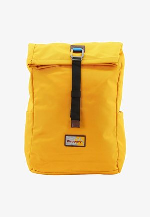 Mochila amarilla tipo roll-top hecha de tela resistente, con una correa negra y un broche de metal, un parche de logo y bolsillos laterales.