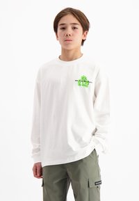 Langarmiger weißer T-Shirt aus Baumwolle mit einem grünen grafischen Design auf der Brust und schwarzem Schriftzug. Lässige Passform.