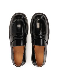 Mocasines de charol negro con un acabado suave, puntera redondeada y correa decorativa. El interior presenta un forro de cuero en color marrón claro.
