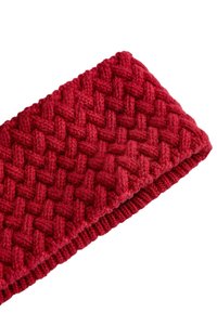 Piros kötött fejpánt, textúrált fonott mintával, puha anyagból készült, és bordázott alsó széllel rendelkezik a biztonságos illeszkedés érdekében.