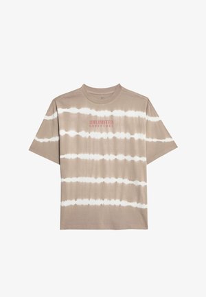 Beige tie-dye t-shirt med korte ærmer og matchende shorts, med et centreret tekstdesign i rødt. Hvide sneakers med cremefarvede såler.