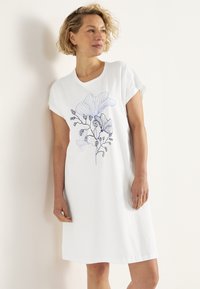 Hvid bomulds kjole med korte ærmer, prydet med en blå blomsterlinjetegning, afslappet pasform og knælængde.