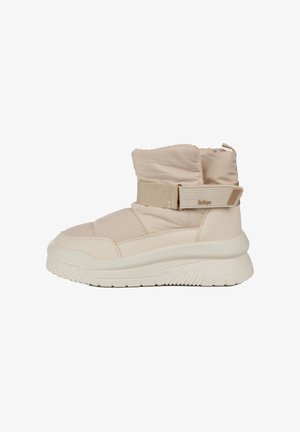 Beżowe botki za kostkę z wyściełanym cholewką, elastycznym paskiem i fakturowanymi akcentami. Masywna biała gumowa podeszwa z zygzakowatym wzorem bieżnika.