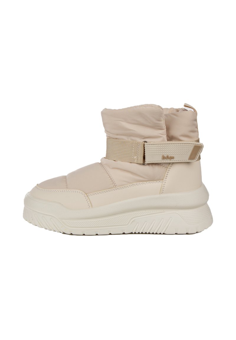 Beżowe botki za kostkę z wyściełanym cholewką, elastycznym paskiem i fakturowanymi akcentami. Masywna biała gumowa podeszwa z zygzakowatym wzorem bieżnika.