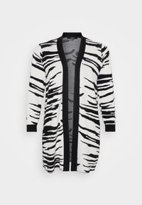 Long cardigan featuring a black and white zebra stripe pattern, with a black trim along the open front and sleeves. Textured fabric.
