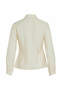 Chemise créme à manches longues avec col, en tissu texturé, coupe droite et poignets boutonnés. La vue arrière montre un design lisse et simple.