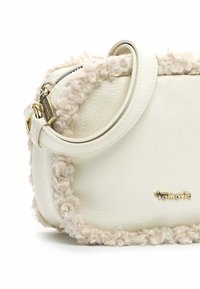 Borsa a tracolla in faux leather bianca con bordo in pelliccia texturizzata color crema, zip dorata e un sottile logo del marchio sul davanti. Design liscio e morbido.