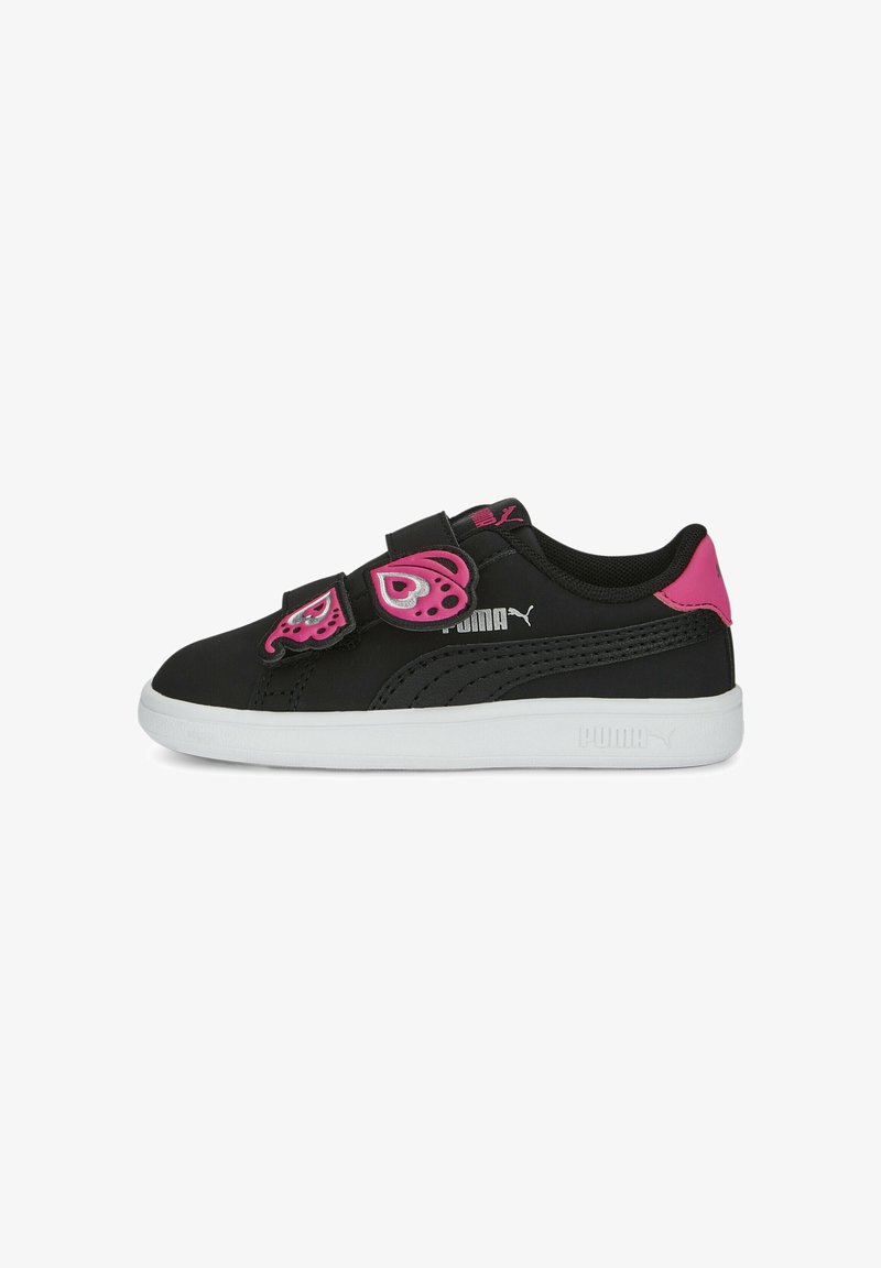 Baskets Puma noires avec semelle blanche, languette rose au talon et deux scratchs roses en forme de papillon sur le côté.