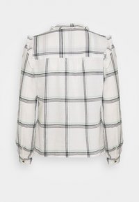 Wit geruit overhemd met zwarte en groene lijnen, met lange mouwen en ruches op de schouders. Knoopsluiting bij de manchetten.