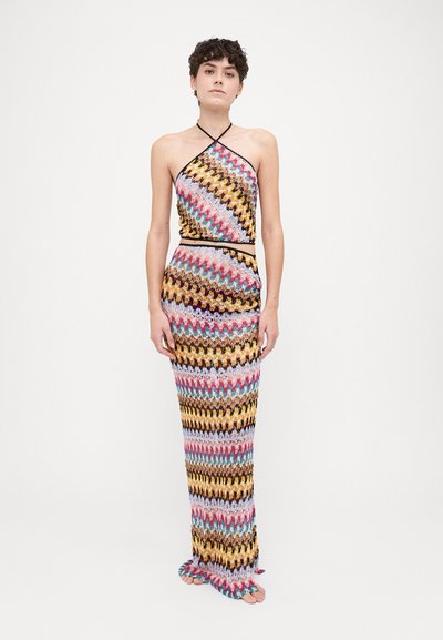 Färgglad zigzag-mönstrad stickad tvådelad uppsättning med halterneck-top och lång kjol. Tyget har flerfärgade trådar med en mjuk textur.