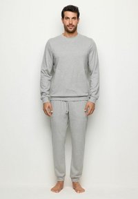 Set de hanorac și pantaloni gri, fabricat dintr-un material moale. Partea superioară are un guler rotund, iar pantalonii dispun de o talie elastică și buzunare.