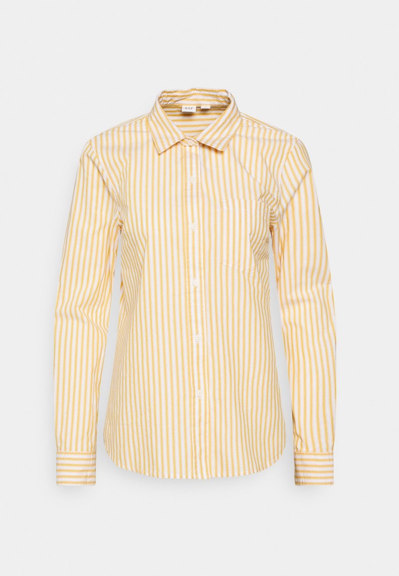 Chemise blanche à rayures verticales jaunes, manches longues, fermeture à boutons, et une poche poitrine. Tissu en coton avec une texture lisse.