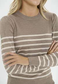 Maglione a righe marroni caratterizzato da un collo rotondo, polsini e orlo a costine, una consistenza morbida e righe alternate crema su tutto il corpo.