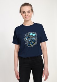 Námořnické tričko vyrobené z bavlny s grafikou skateboardisty, obsahující modré, šedé a žluté detaily, a s volným střihem.