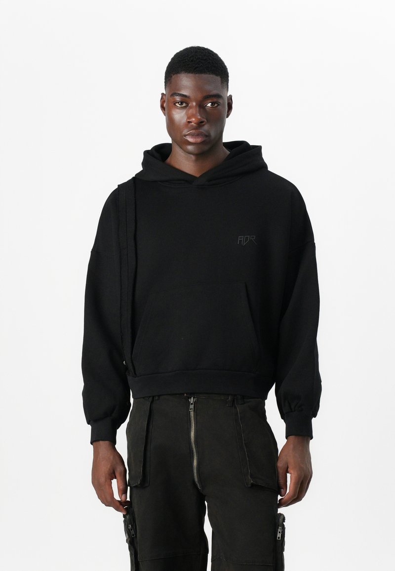 Sort hætte sweatshirt med en frontlomme og ribbede manchetter. Har et minimalistisk logo på brystet og en afslappet pasform.