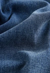 Tela de denim azul oscuro con textura de tejido visible, que presenta un acabado suave y sutiles variaciones en color y sombreado.