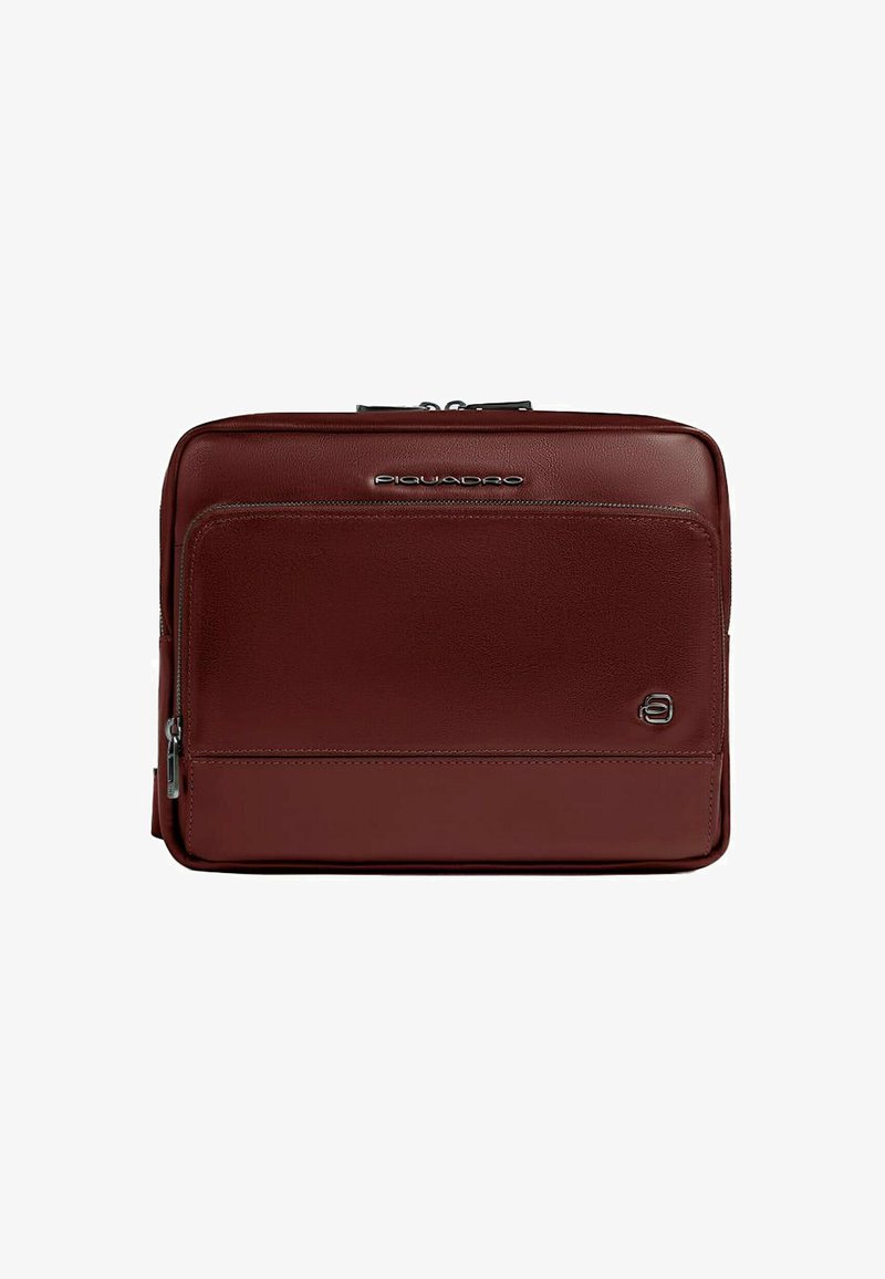 Bolsa para portátil de cuero marrón con textura suave, compartimentos con cremallera y detalle de logo. Presenta un diseño rectangular elegante.