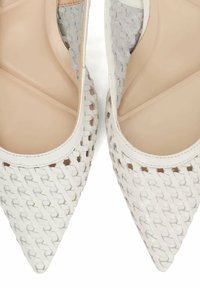 Witte geweven leren puntige flats met beige interieur en textuurpatronen op het buitenoppervlak. Translucente accenten aan de zijkanten.