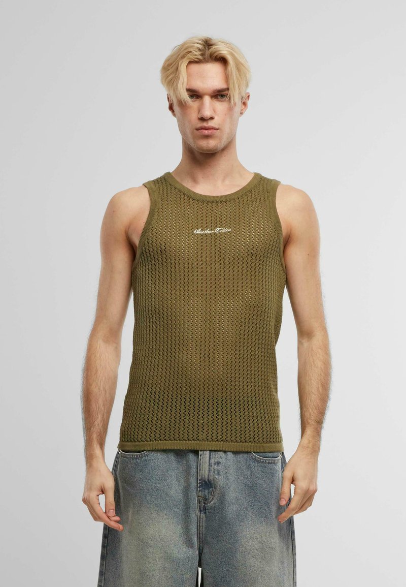 Canotta a maglia verde oliva con design a rete, caratterizzata da un colletto tondo e lettering bianco lungo il petto. Vestibilità non strutturata.