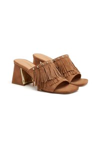 Mules en suède marron avec des détails en franges, accent doré sur un talon bloc, design à bout ouvert et semelle plates.