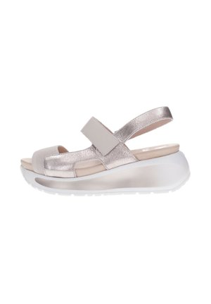 Sandalia de mujer plateada metálica con punta abierta, tira ajustable y suela gruesa blanca acolchada de plataforma, vista lateral sobre fondo blanco.