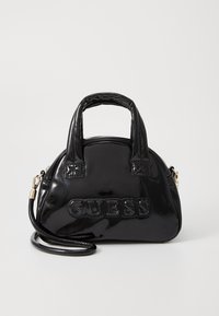 Schwarze Lackleder-Handtasche mit runder Form, oberen Tragegriffen und einem abnehmbaren Schulterriemen. Verfügt über das eingeprägte "GUESS"-Logo.
