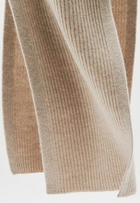 Beige strikket tørklæde med ribbet tekstur, der har en gradvis farveovergang fra lys til mørk. Blødt og varmt materiale.