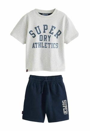 Jasnoszara koszulka z krótkim rękawem z napisem "SUPER DRY ATHLETICS", zestawiona z granatowymi szortami z elastycznym pasem i napisem "SUPER DRY" na nodze.