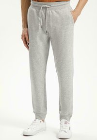 Szare dresowe spodnie z miękkiego materiału, z elastycznym pasem na sznurki, bocznymi kieszeniami i ściągaczami na kostkach. Subtelny detal logo na nodze.