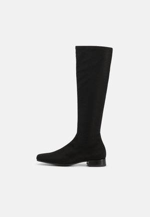 Bottes noires montantes en tissu lisse avec un design épuré, bout pointu et un petit talon bloc. Pas de métal apparent ni d'accents.